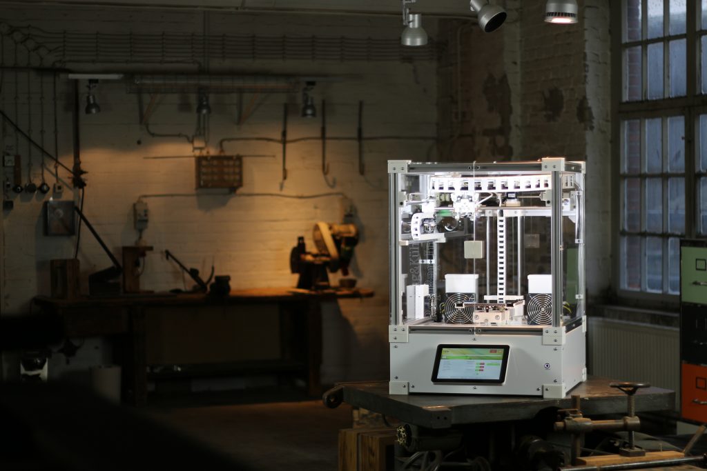 A 3D printer on top of a counter in a workshop