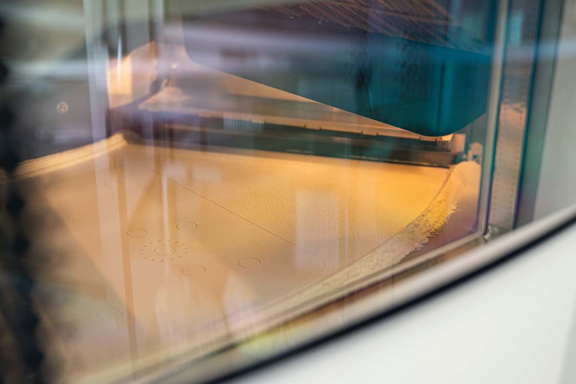 An SLS printer in the igus motion plastics print lab creates custom wear-resistant parts out of iglide 3D printing material